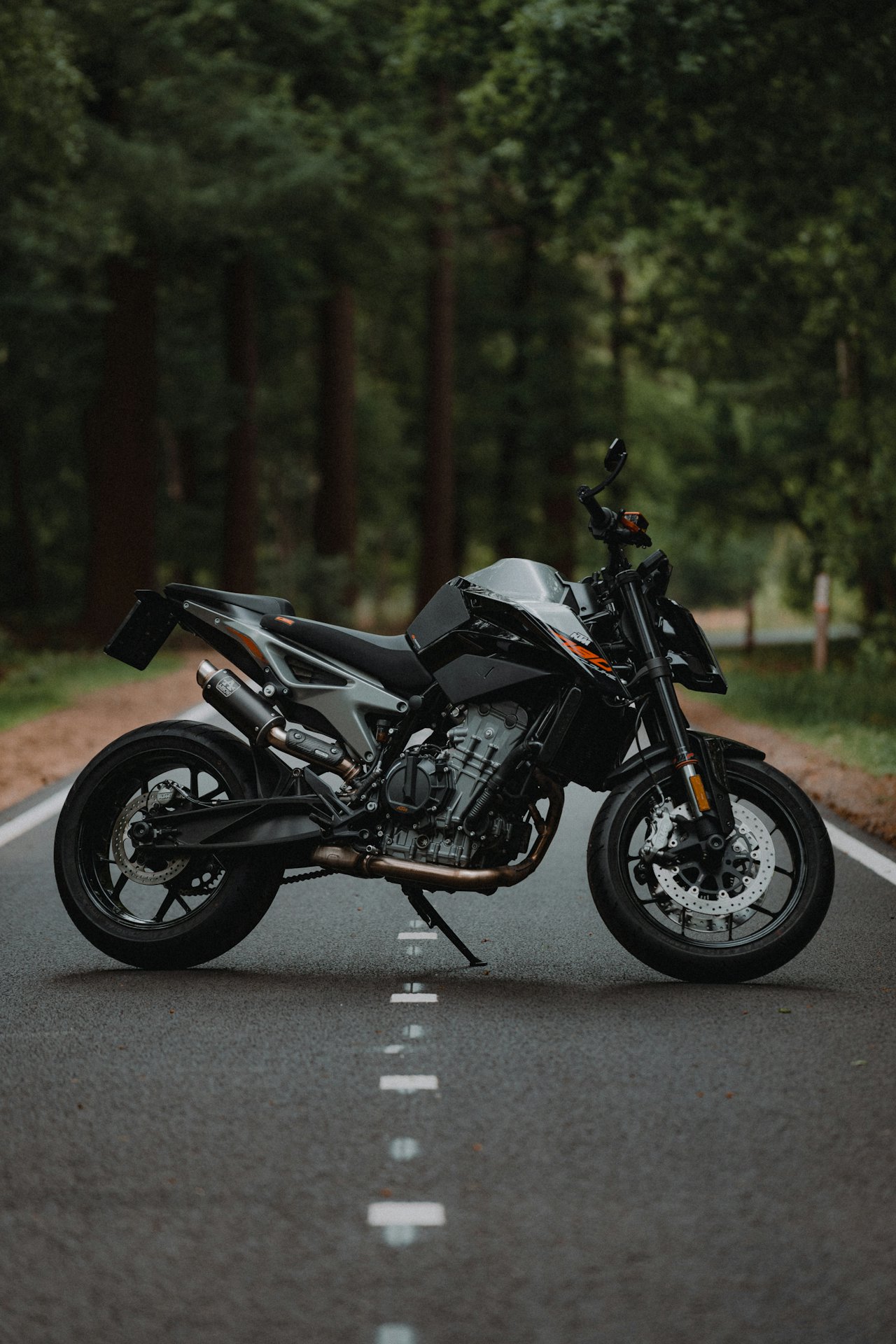 Motorcycle commuting along a wet, salt-streaked road under grey winter light