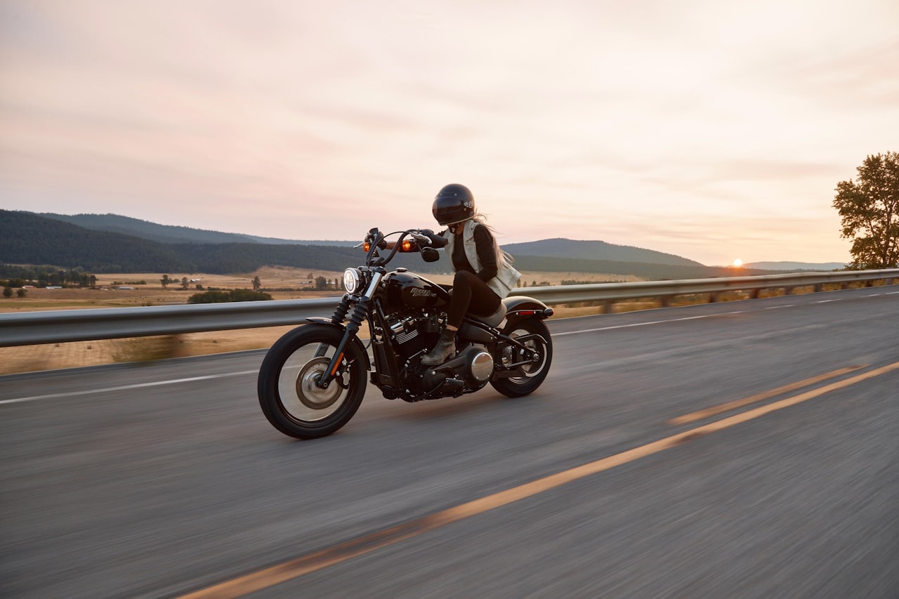 A simple analogue motorcycle with a single round dial parked on a dusty rural road