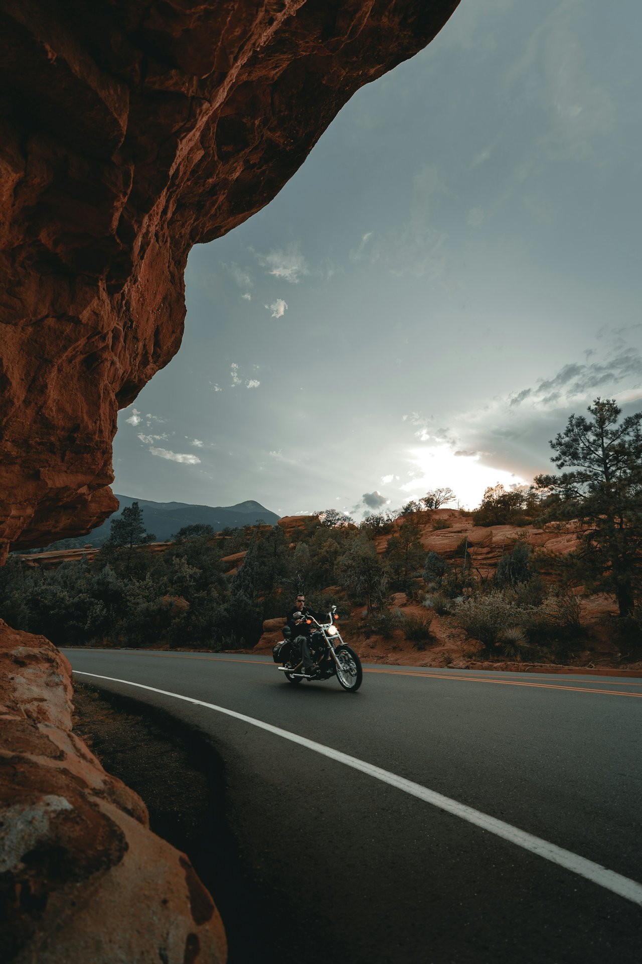 A heavyweight touring motorcycle with full fairing and integrated luggage parked beside a tall adventure-sport motorcycle with spoked wheels at a scenic roadside overlook
